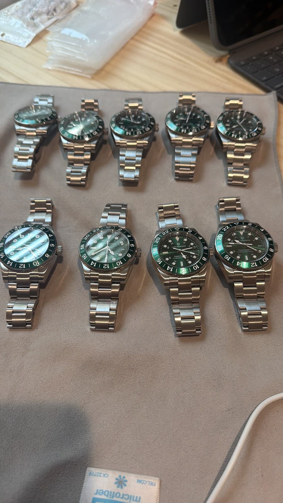 Twenty green watches laid out before the golf trip